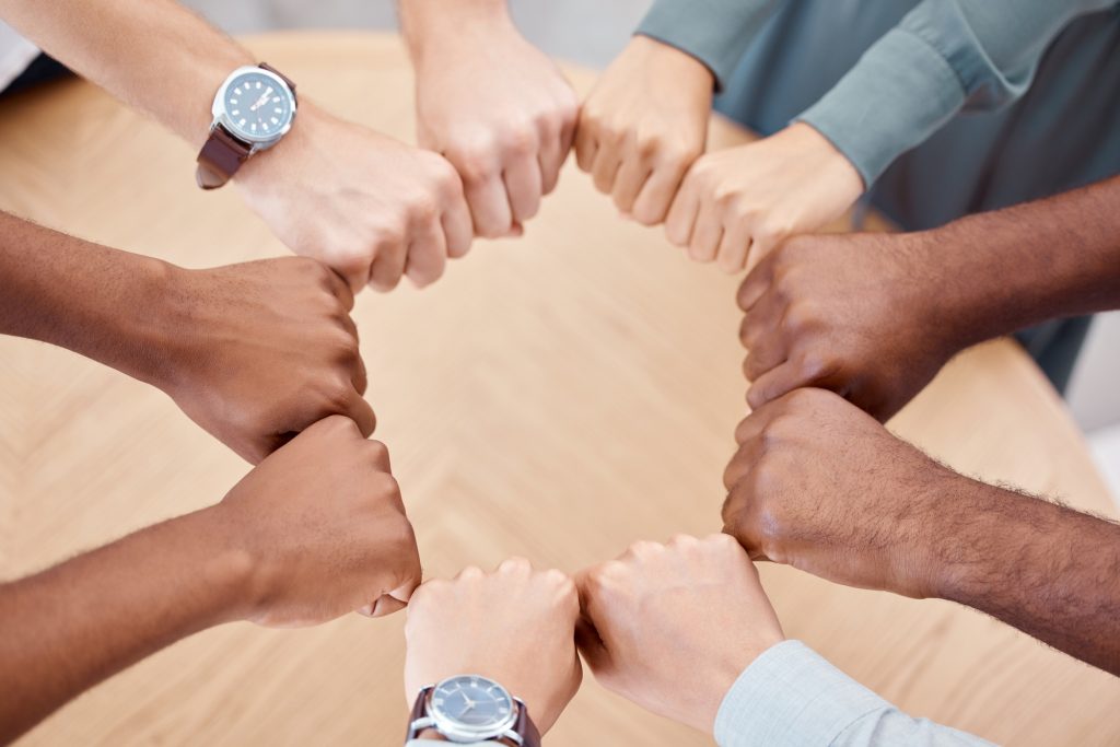 Circle, fist and diversity for solidarity, above and teamwork in office for power, unity and collab